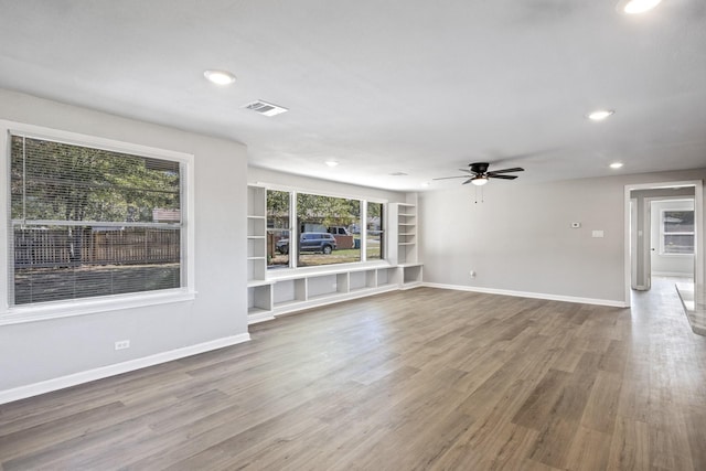 unfurnished living room with ceiling fan and hardwood / wood-style floors