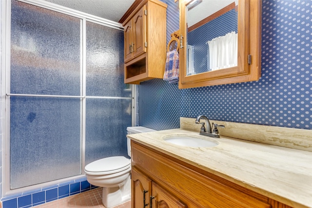 bathroom with vanity, tile patterned flooring, toilet, walk in shower, and a textured ceiling