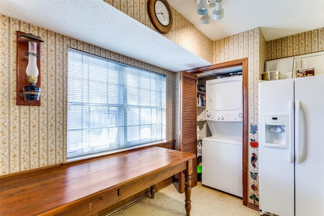 laundry area with a textured ceiling and stacked washer and dryer