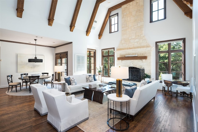 living room with beamed ceiling, a high ceiling, a stone fireplace, and dark hardwood / wood-style flooring