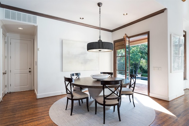 dining space featuring ornamental molding and dark hardwood / wood-style flooring