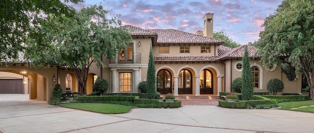 mediterranean / spanish-style home featuring a carport and a balcony