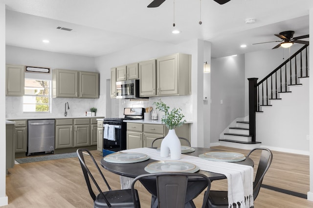 kitchen featuring ceiling fan, stainless steel appliances, tasteful backsplash, light hardwood / wood-style flooring, and gray cabinets