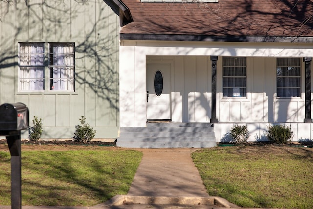 doorway to property with a lawn and covered porch