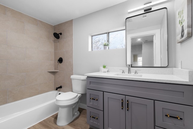 full bathroom featuring vanity, toilet, wood-type flooring, and tiled shower / bath