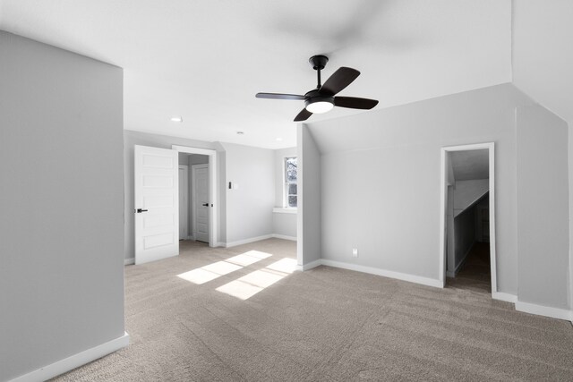 interior space featuring light carpet, ceiling fan, and vaulted ceiling