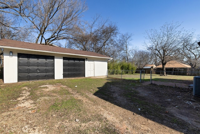 garage featuring a lawn and cooling unit