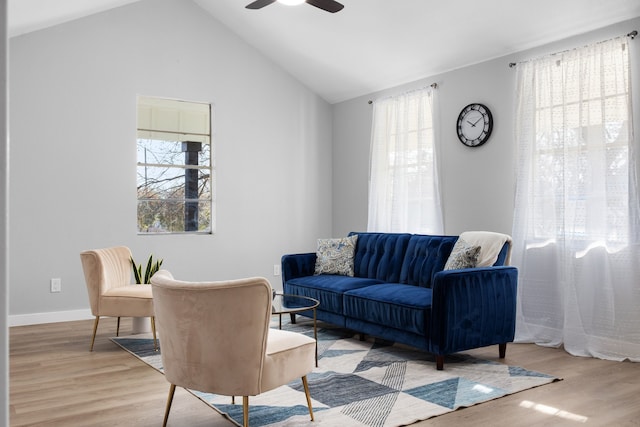 living room featuring ceiling fan, vaulted ceiling, and light wood-type flooring