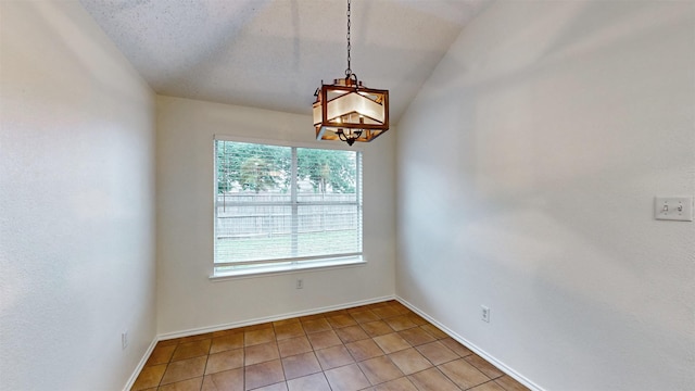 empty room with tile patterned floors, a textured ceiling, and lofted ceiling