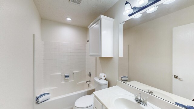 full bathroom featuring vanity, a textured ceiling, shower / bath combination, and toilet