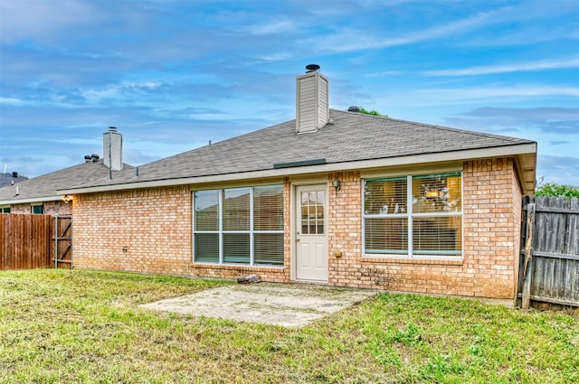 back of house with a lawn and a patio