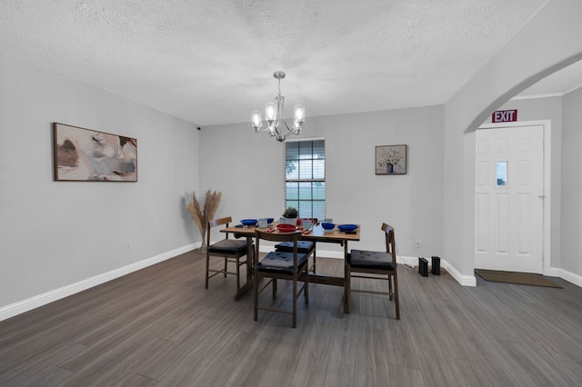 dining room with a textured ceiling, dark hardwood / wood-style floors, and a notable chandelier