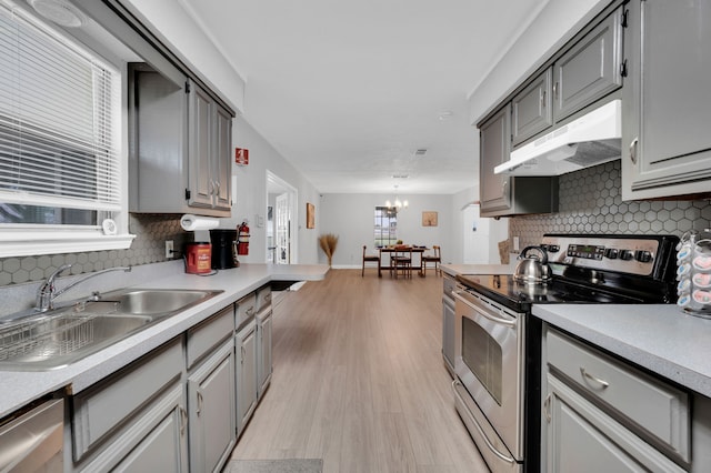 kitchen featuring sink, a notable chandelier, light hardwood / wood-style floors, gray cabinets, and appliances with stainless steel finishes