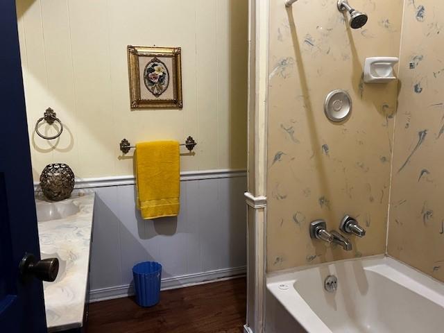 bathroom with hardwood / wood-style flooring and shower / washtub combination