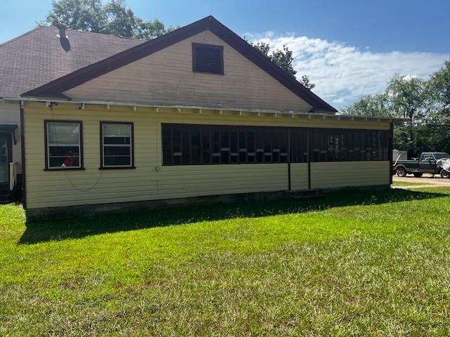 view of side of home with a yard