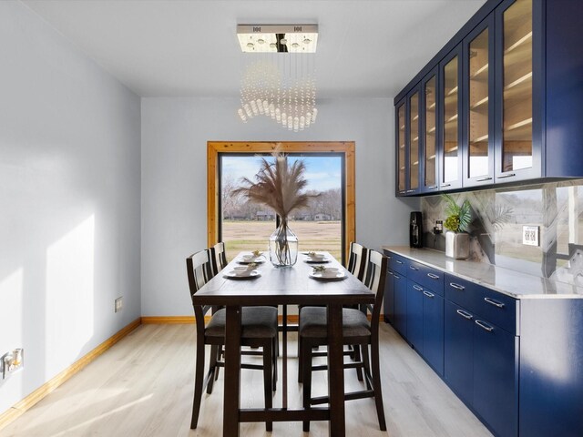 kitchen featuring sink, stainless steel appliances, tasteful backsplash, light hardwood / wood-style floors, and blue cabinets