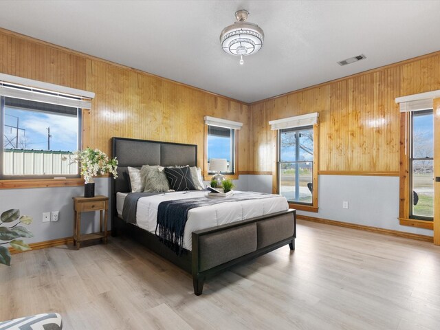 bedroom with a textured ceiling, vaulted ceiling, wooden walls, and wood-type flooring