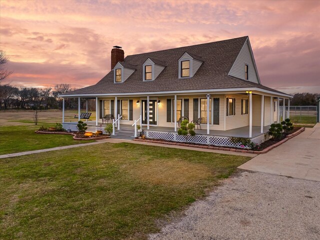 farmhouse-style home featuring a yard and covered porch