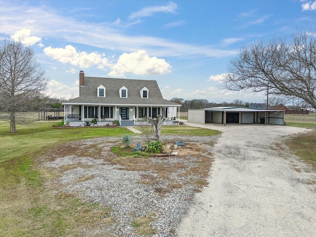 farmhouse with covered porch, an outbuilding, a garage, a carport, and a front lawn