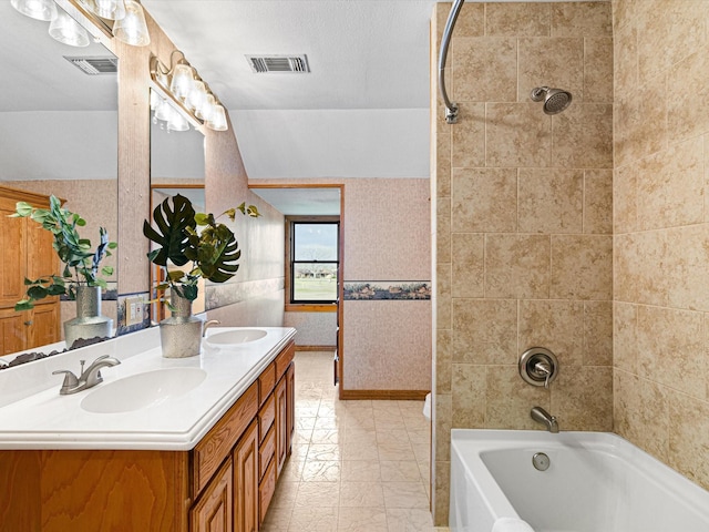 bathroom with bathtub / shower combination, a sink, and visible vents