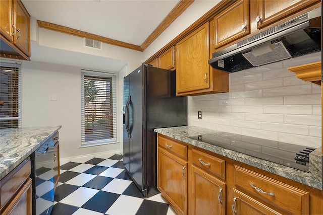 kitchen featuring light stone countertops, backsplash, ornamental molding, and black appliances