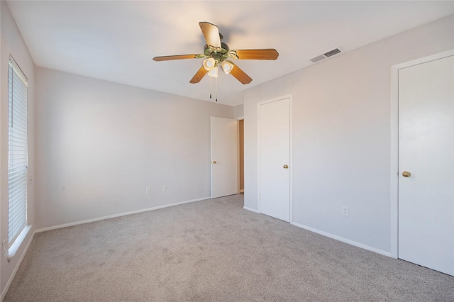 unfurnished bedroom featuring ceiling fan and light carpet