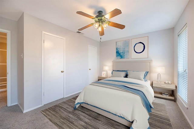 bedroom with carpet flooring, ceiling fan, a closet, and multiple windows