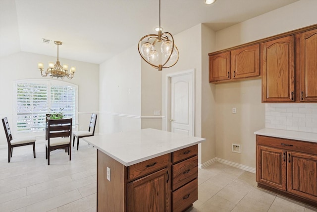 kitchen featuring decorative backsplash, light tile patterned flooring, hanging light fixtures, and a chandelier