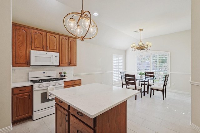 kitchen featuring an inviting chandelier, tasteful backsplash, pendant lighting, vaulted ceiling, and white appliances