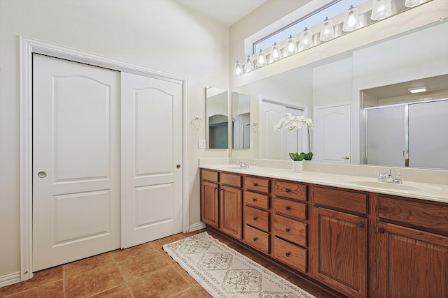 bathroom with tile patterned flooring, vanity, and a shower with door