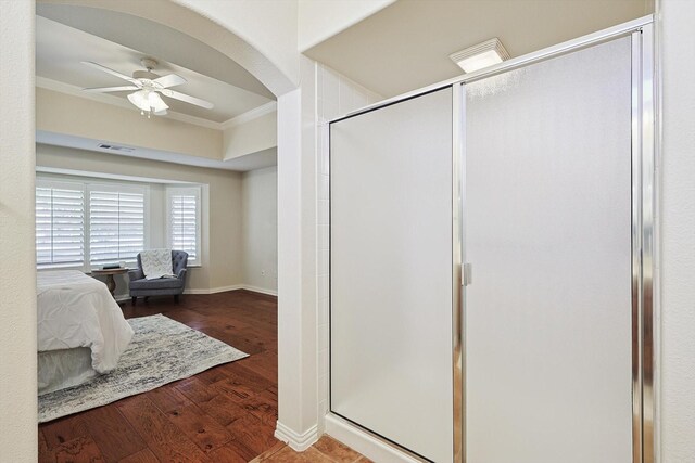 bathroom with ceiling fan, ornamental molding, a shower with shower door, and hardwood / wood-style flooring