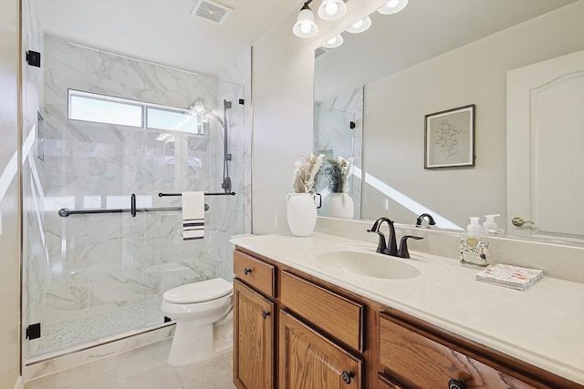 bathroom with tile patterned flooring, vanity, a shower with shower door, and toilet