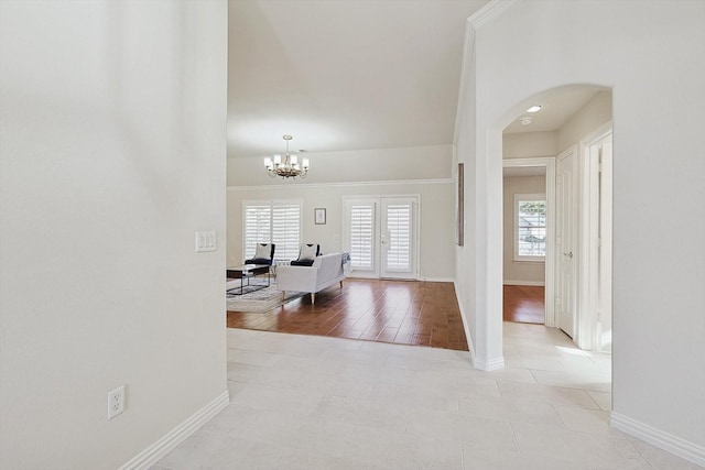 corridor with plenty of natural light, light tile patterned floors, and french doors