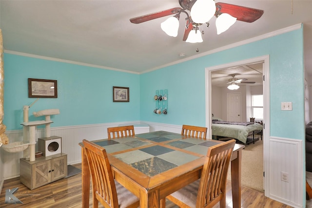 dining room with hardwood / wood-style flooring, ceiling fan, and ornamental molding