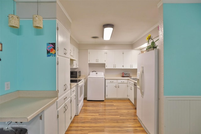 kitchen featuring washer / dryer, stainless steel appliances, white cabinetry, and crown molding