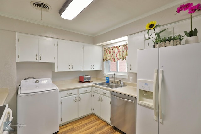 kitchen with dishwasher, sink, white refrigerator with ice dispenser, washer / dryer, and white cabinets