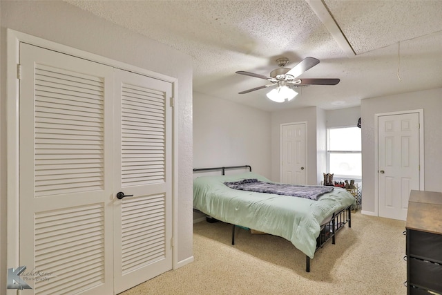 bedroom with a textured ceiling, carpet floors, and ceiling fan