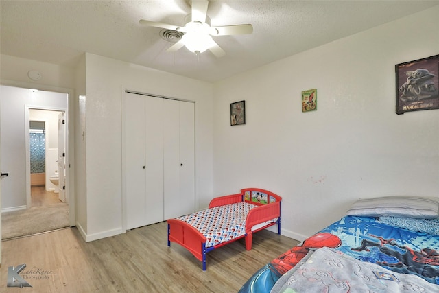 bedroom with ceiling fan, a closet, and light hardwood / wood-style flooring