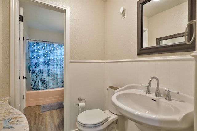 full bathroom with toilet, hardwood / wood-style flooring, sink, and shower / tub combo with curtain