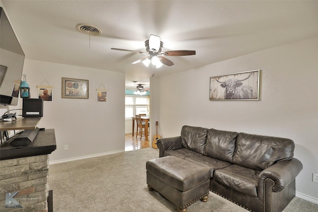 carpeted living room with ceiling fan