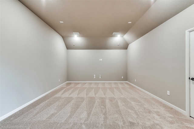 unfurnished room with light carpet and vaulted ceiling