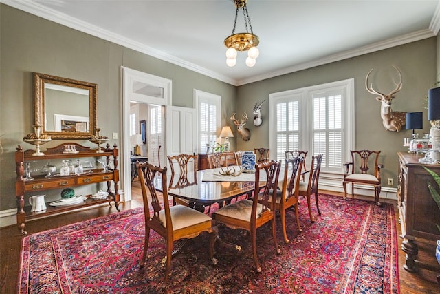 dining room with wood-type flooring, an inviting chandelier, and ornamental molding