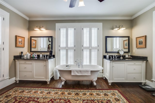 bathroom with hardwood / wood-style floors, vanity, a tub to relax in, and a wealth of natural light