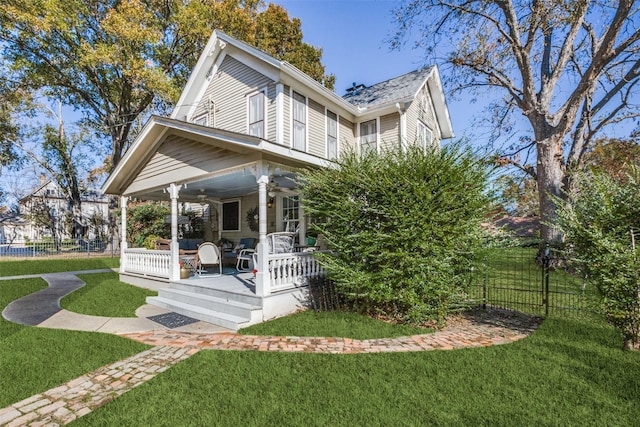 view of front of house featuring ceiling fan and a front lawn