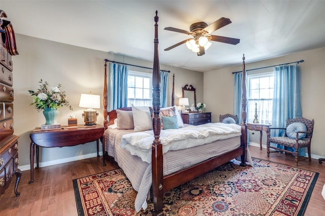 bedroom with multiple windows, wood-type flooring, and ceiling fan