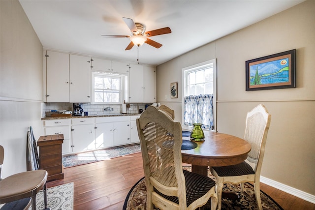 dining space with hardwood / wood-style flooring and ceiling fan