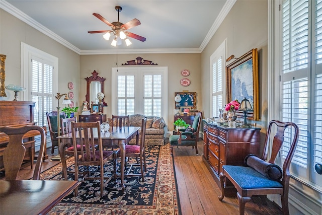 dining area with a wealth of natural light, crown molding, ceiling fan, and wood-type flooring