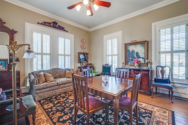 dining space featuring ceiling fan, hardwood / wood-style floors, and crown molding