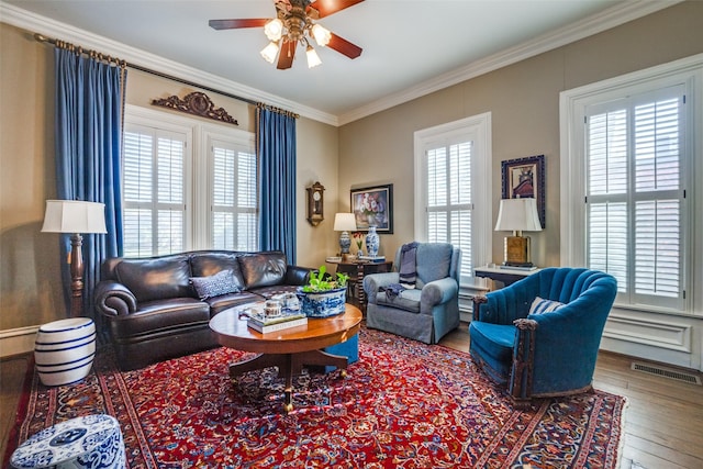 living room featuring hardwood / wood-style flooring, ceiling fan, and crown molding