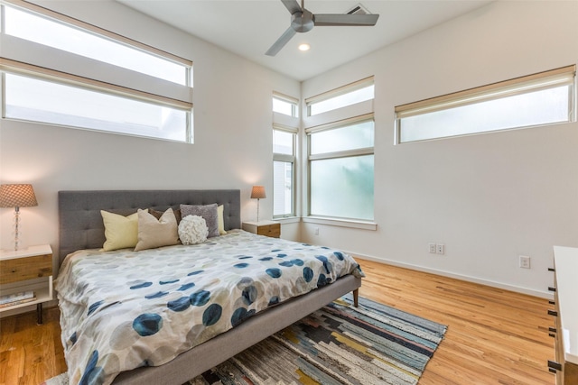 bedroom featuring multiple windows, ceiling fan, and hardwood / wood-style floors